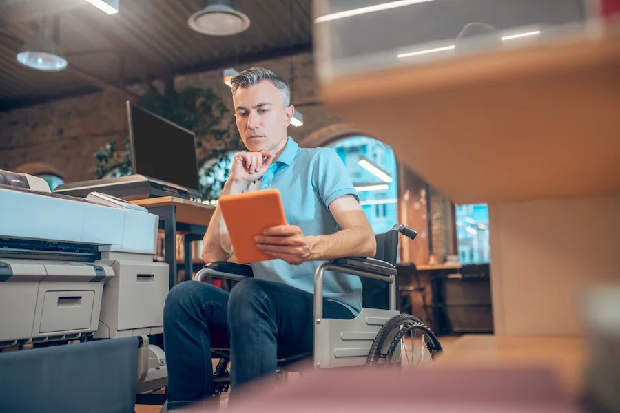 Persona con discapacidad en entorno laboral | Foto de 123RF/sergiyzinkevych