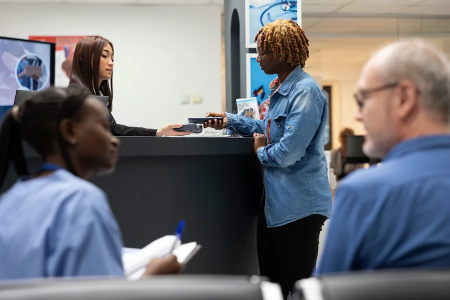 Personas migrantes hacen tramites en una oficina | Foto de 123RF/dragoscondrea