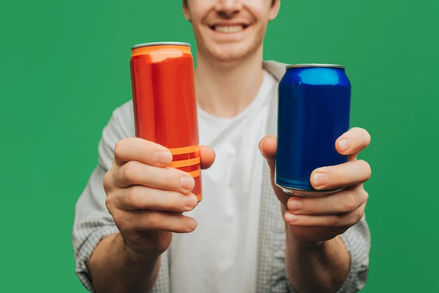 Un menor sostiene dos latas de bebidas energéticas | Foto de 123RF/avistock